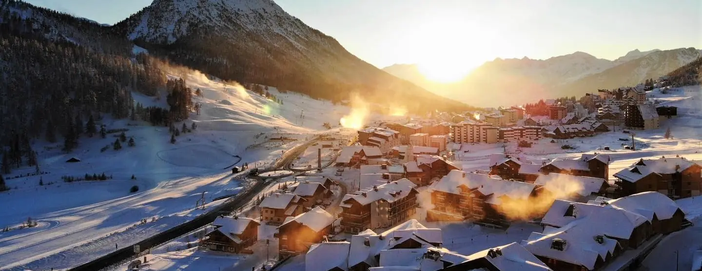 Le village de Montgenèvre sous la neige, éclairé par le soleil rasant de fin de journée