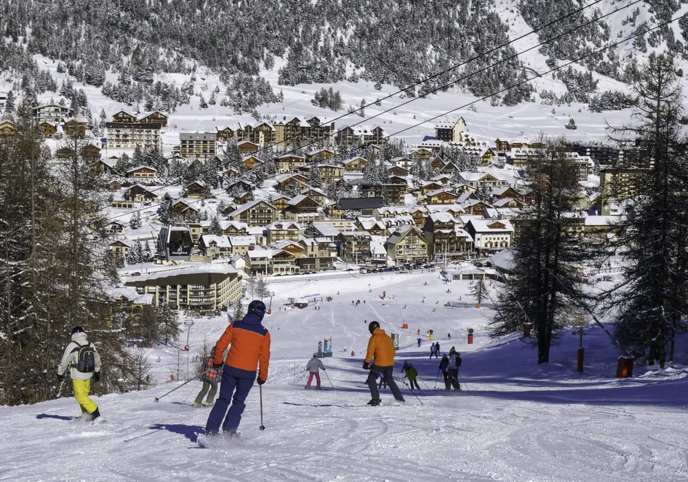 Skieurs descendant vers le village enneigé de Montgenèvre